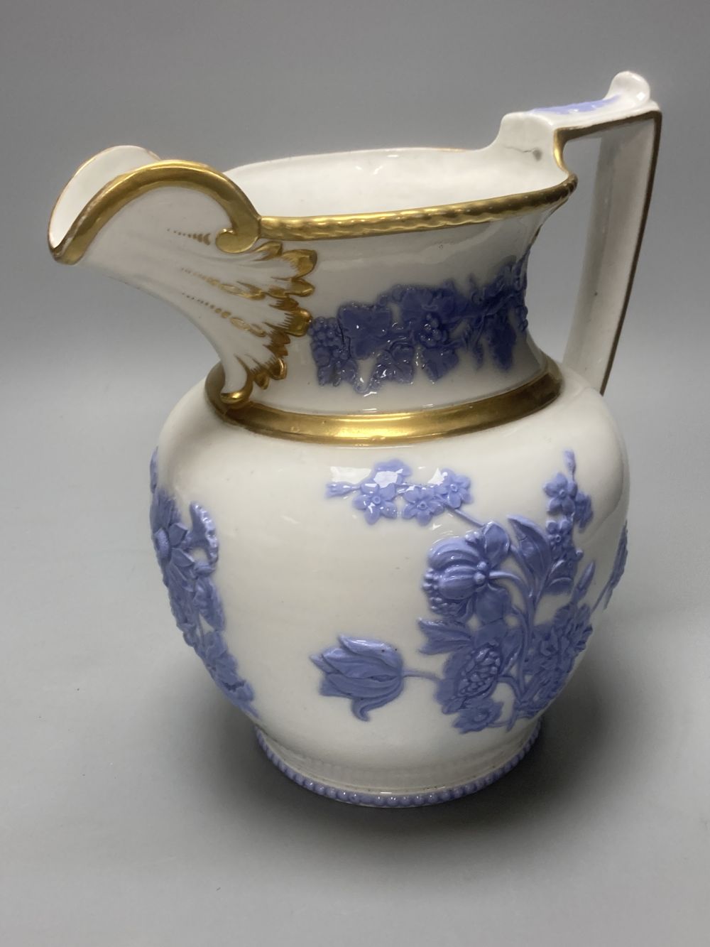 Four early 19th century Staffordshire jugs, each with lilac coloured floral applied panels, one dated 1826, tallest 22cm